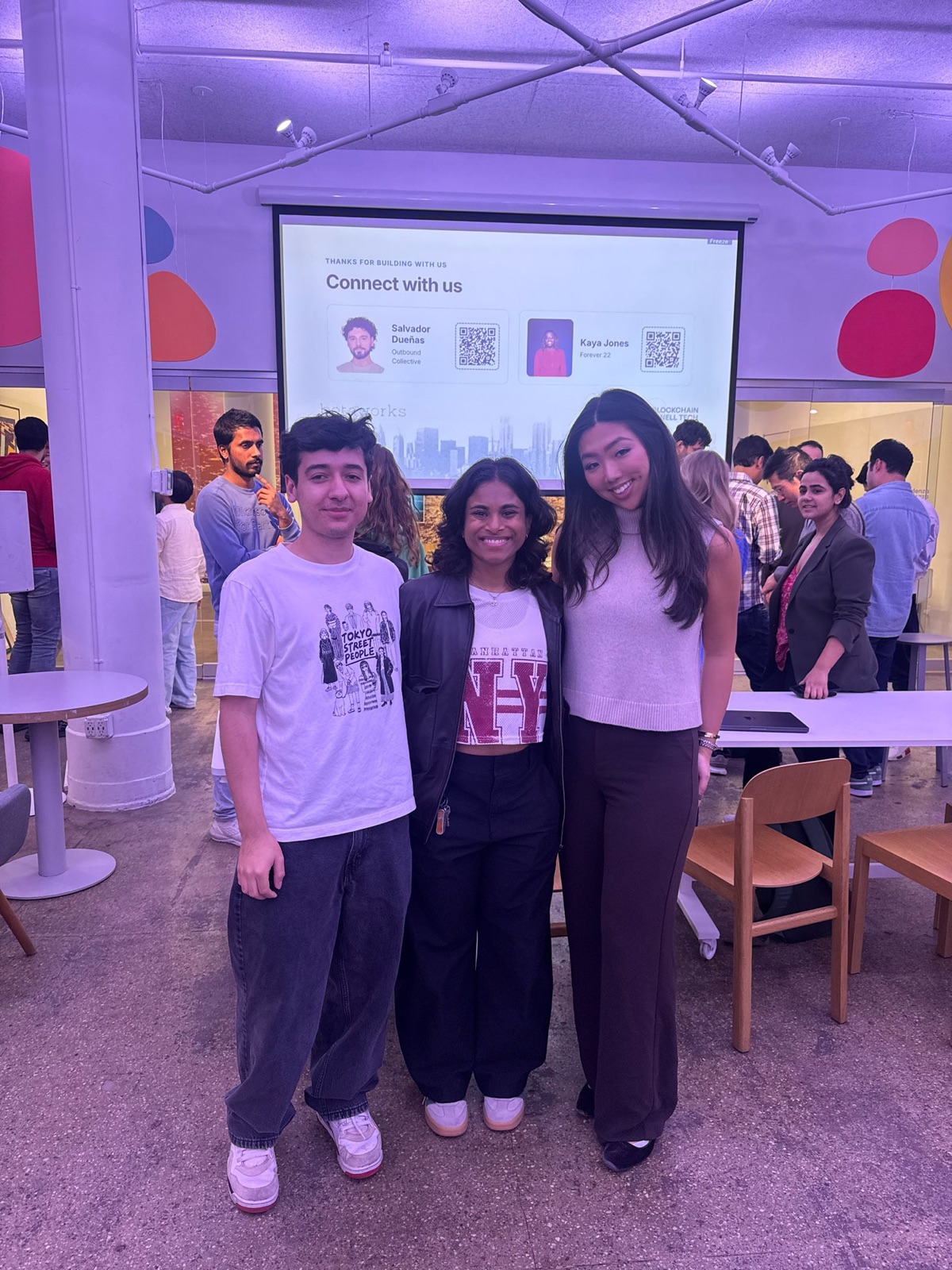 A hackathon team posing in front of their projected demo