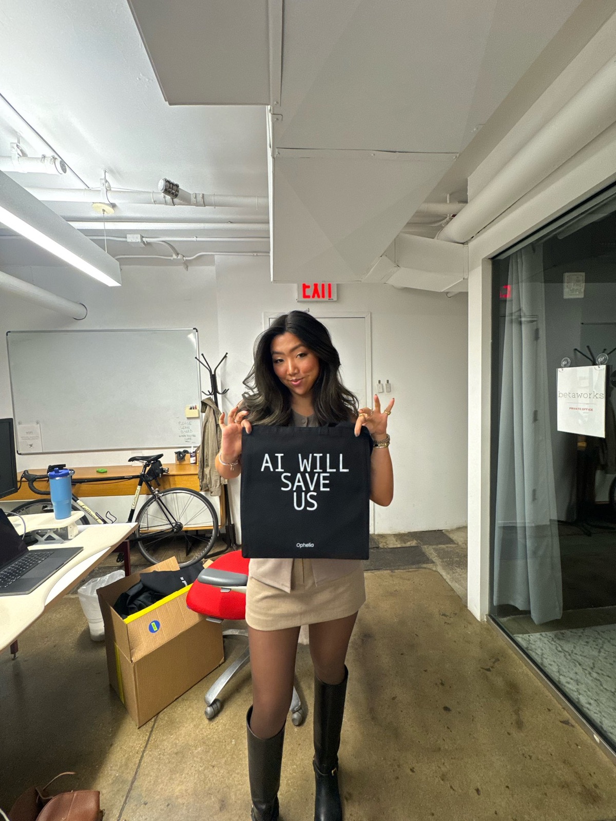 A guest holds up an AI will save us tote bag