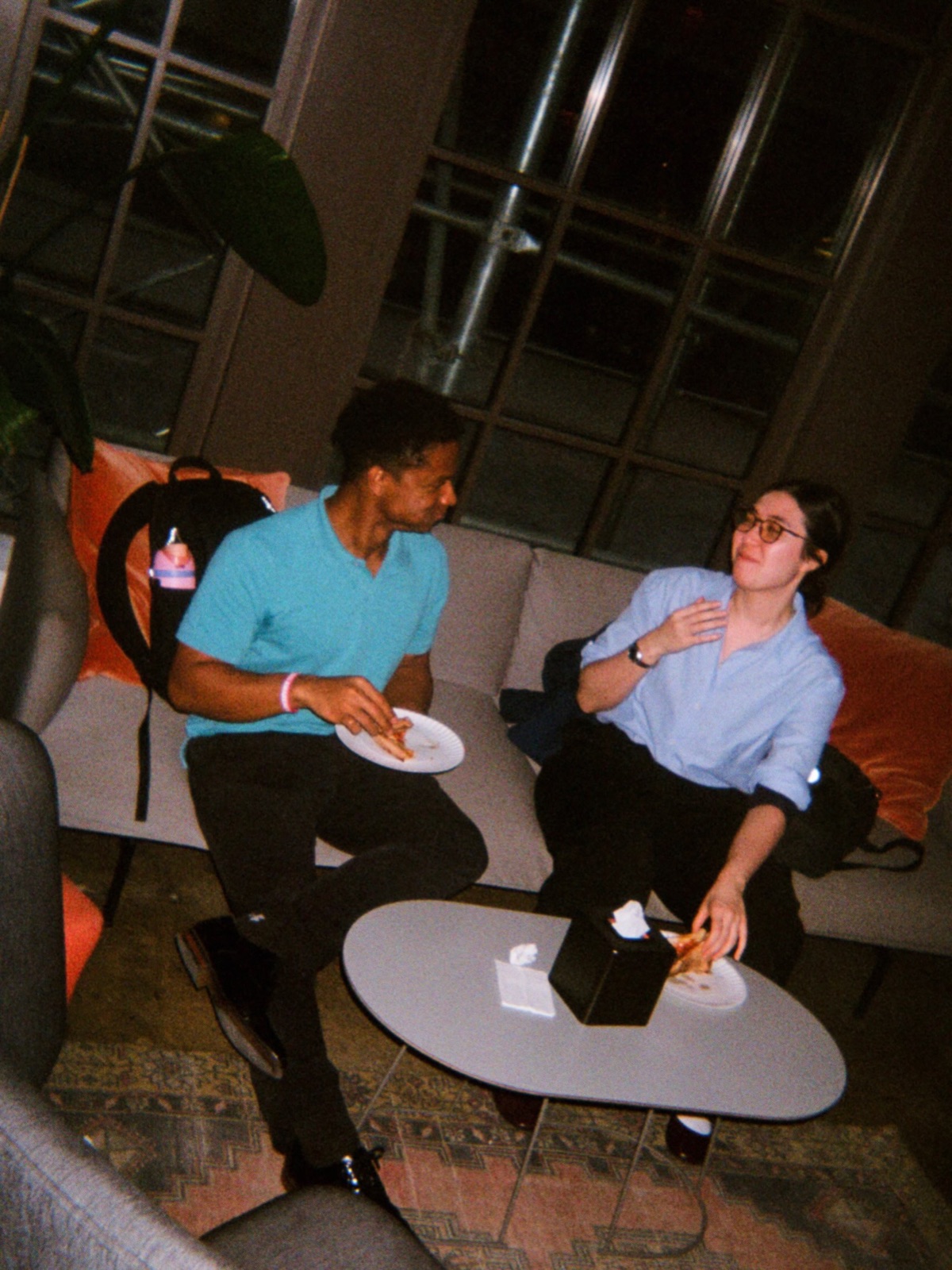 Two guests chatting on a low sofa