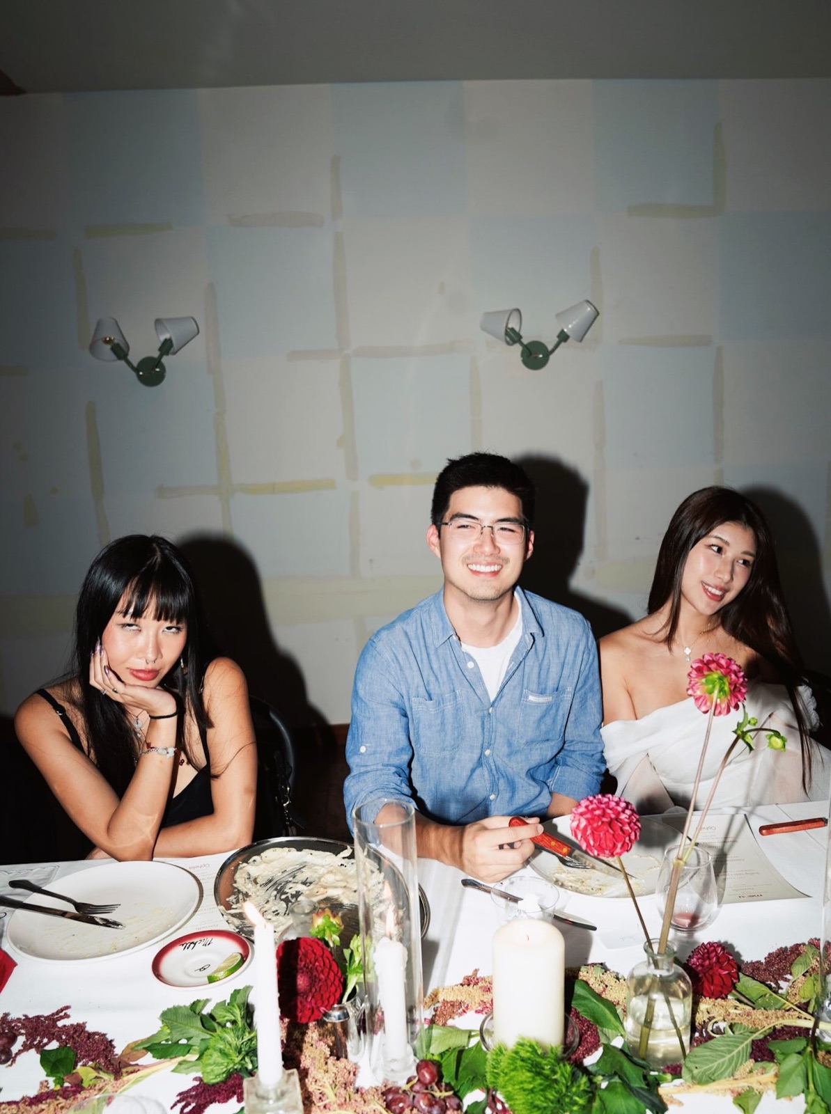Three guests seated at the candlelit dinner table