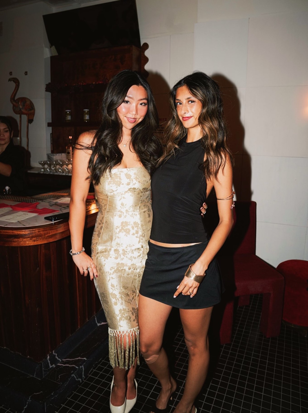Two guests in evening dresses pose together